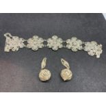 A WHITE METAL FLOWER DESIGN BANGLE WITH EARRINGS POSSIBLY SILVER