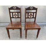 A PAIR OF VICTORIAN MAHOGANY HALL CHAIRS WITH INSET TILE BACKS