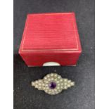 AN ART DECO STYLE MARKED SILVER BROOCH WITH PEARLS AND PURPLE COLOURED STONE