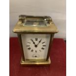A FRENCH BRASS CARRIAGE CLOCK WITH WHITE ENAMEL DIAL AND SECONDHAND FEATURE (KEY) - 11CM HIGH