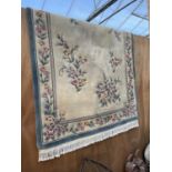 A LARGE CREAM AND BLUE FLORAL PATTERNED RUG
