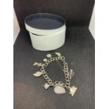 A SILVER CHARM BRACELET WITH NINE CHARMS WITH A PRESENTATION BOX