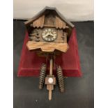 A BLACK FOREST CARVED CUCKOO CLOCK WITH FIR TREE AND WATER PUMP DECORATION. COMPLETE WITH TWO