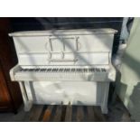 A WHITE PAINTED UPRIGHT PIANO