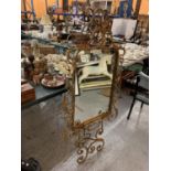 A LARGE MIRROR ON A GILT STAND