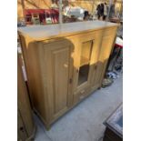 A 'G-PLAN CABINETS' OAK CABINET WITH GLAZED CENTRE CUPBOARD, PANELLED SIDE CUPBAORDS AND TWO SMALL