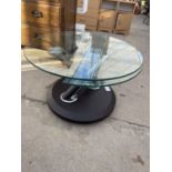 A MODERNISTIC CIRCULAR COFFEE TABLE ON SWIVEL ACTION BASE WHICH EXTENDS TABLE SIZE