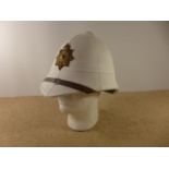 A ROYAL MARINES WHITE PITH HELMET AND BADGE