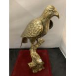 A LARGE BRASS SCULPTURE OF A BIRD OF PREY - 39CM HIGH