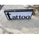 A LARGE ILLUMINATED 'TATTOO' SIGN