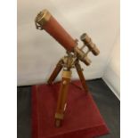 A BRASS AND LEATHER TELESCOPE ON A WOODEN BASE H: 35CM