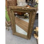 A DECORATIVE GILT FRAMED PORTRAIT ORIENTATED MIRROR (67X55CM)