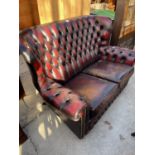 AN OXBLOOD TWO SEATER BUTTON-BACK SETTEE