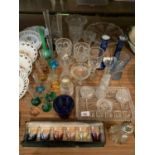 A SELECTION OF GLASSWARE INCLUDING A SUGAR SHAKER, BUD VASES, SHOT GLASSES ETC