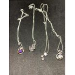FOUR SILVER NECKLACES WITH CLEAR STONE PENDANTS TO INCLUDE A CUBE, STARS ETC