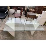 A MODERN GLASS TOPPED COFFEE TABLE, 60x30" ON TWO TRIANGULAR SHAPED POLISHED MARBLE EFFECT BASE