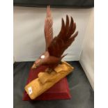 A WOODEN CARVED BIRD OF PREY CATCHING A FISH
