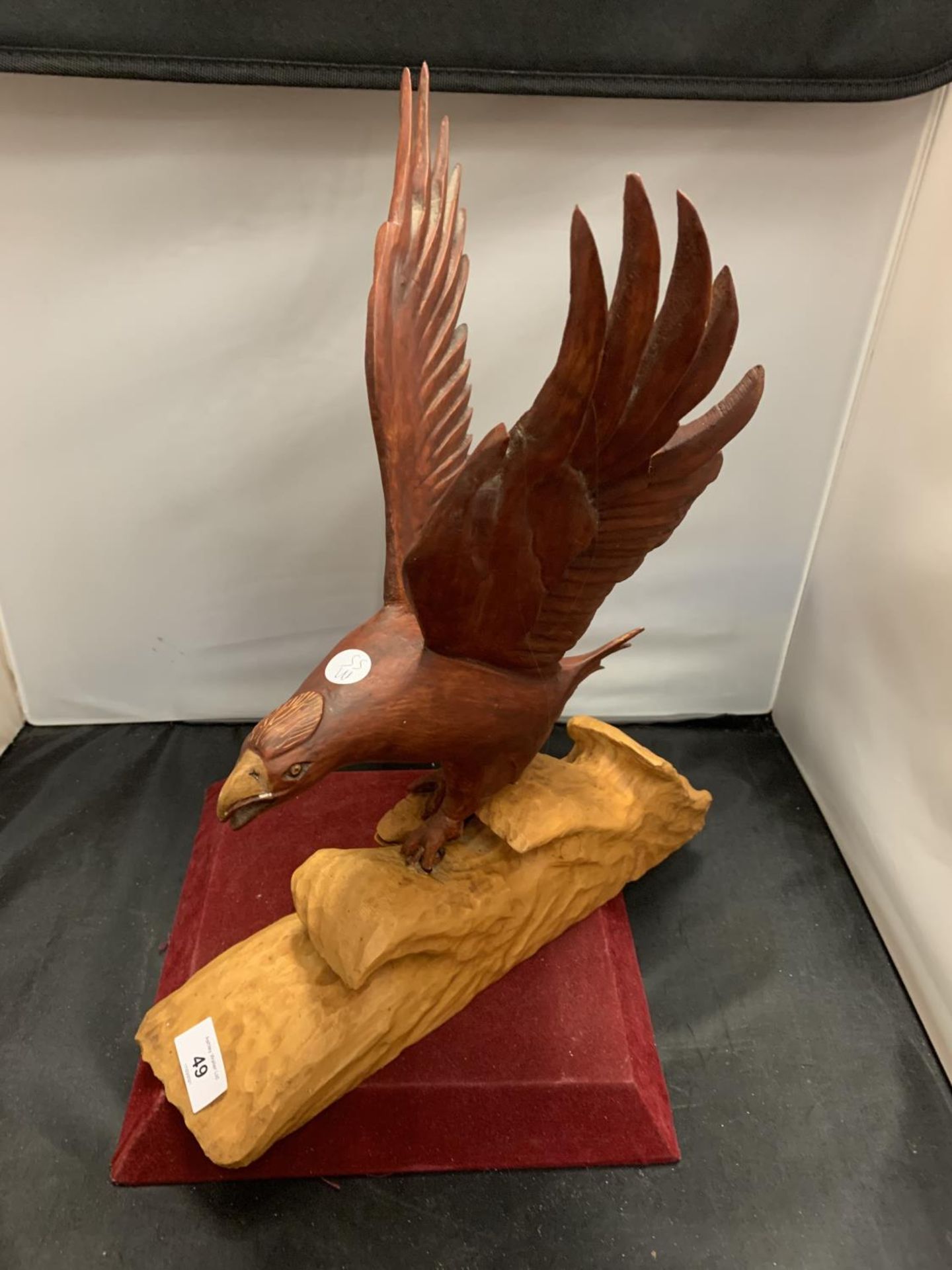 A WOODEN CARVED BIRD OF PREY CATCHING A FISH