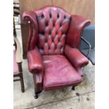 AN OXBLOOD WINGED ARMCHAIR ON CABRIOLE LEGS