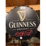 A WALL MOUNTED 'GUINNESS' BOTTLE TOP METAL SIGN