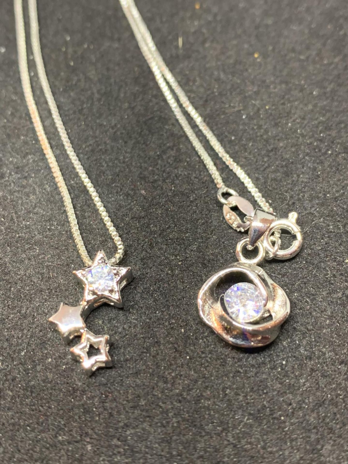 FOUR SILVER NECKLACES WITH CLEAR STONE PENDANTS TO INCLUDE A CUBE, STARS ETC - Image 5 of 6