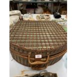 A LARGE WICKER PICNIC BASKET CONTAINING PLATES, CUPS AND CUTLERY FOR FOUR PEOPLE