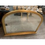 A LARGE ARCHED GILT FRAMED BEVEL EDGE OVERMANTEL MIRROR