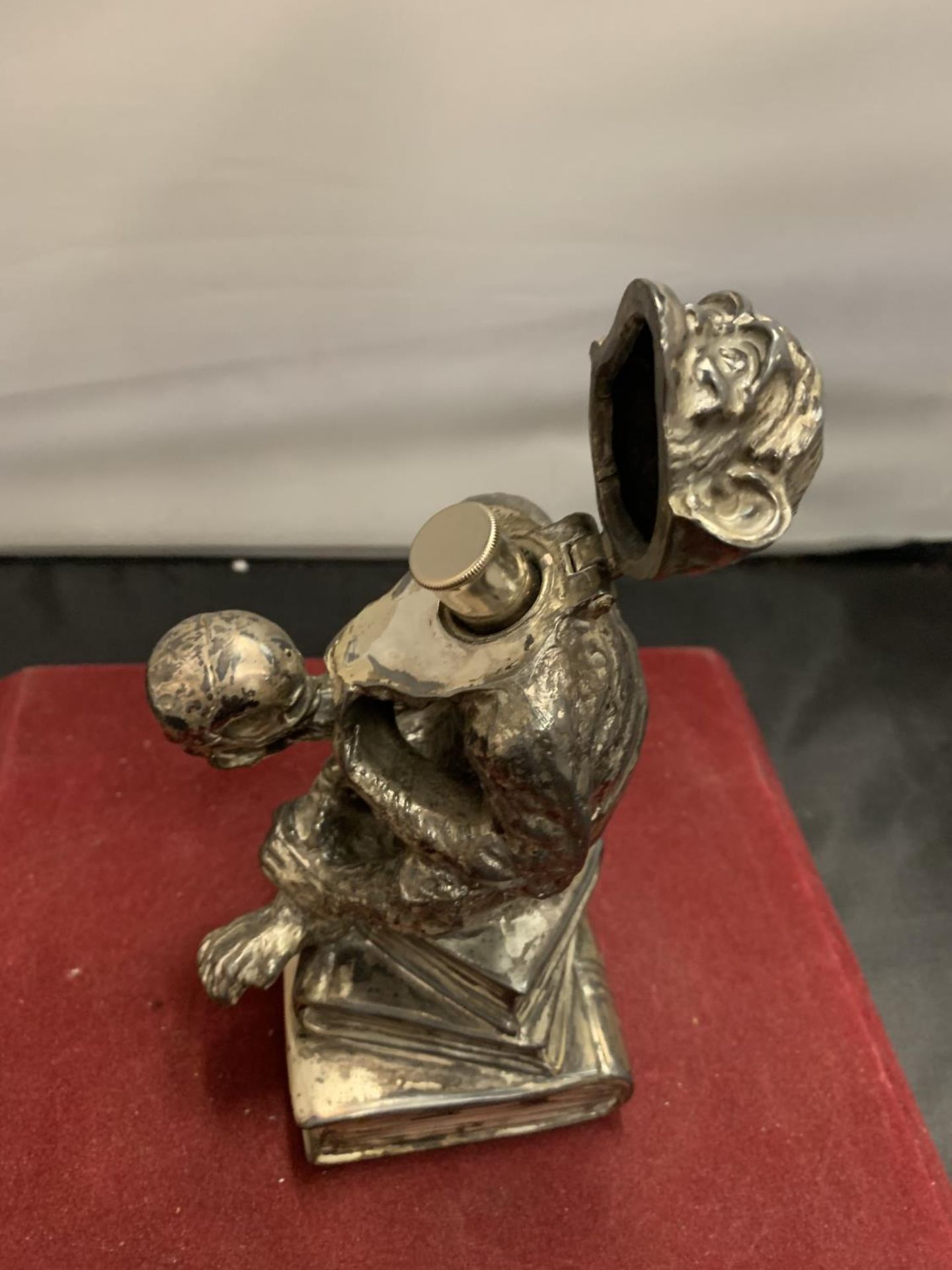 A CAST WHITE METAL TABLE LIGHTER IN THE FORM OF A MONKEY HOLDING A SKULL - Image 5 of 8