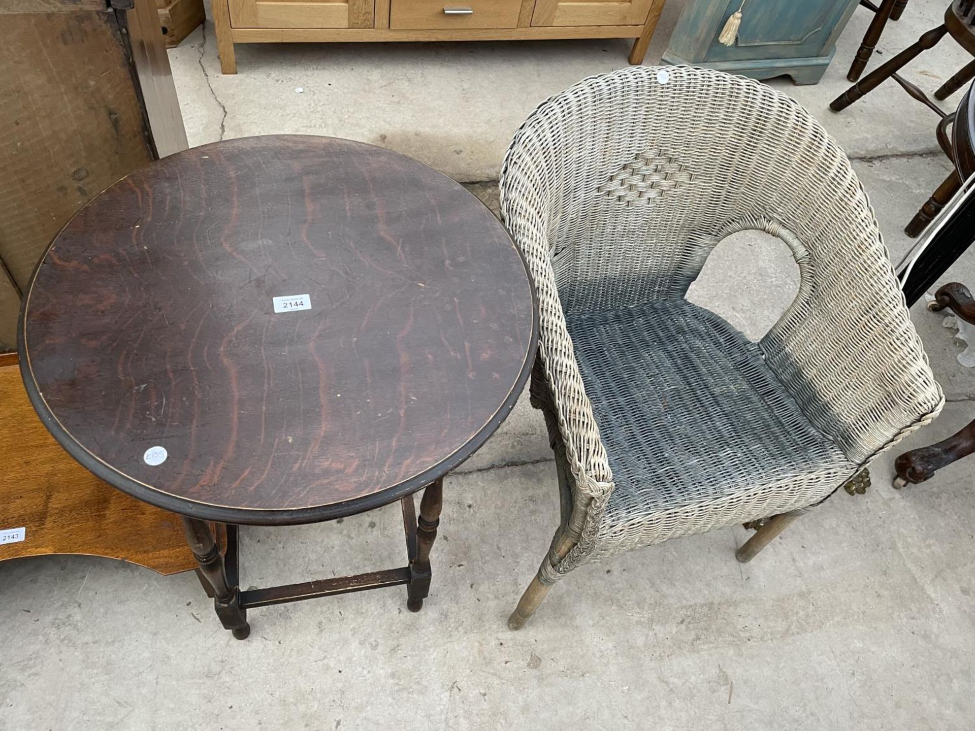 A CIRCULAR OAK OCCASIONAL TABLE AND A LLOYD LOOM STYLE CHAIR