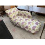 A MODERN FLORAL CHAISE LONGUE WITH TURNED LEGS AND BRASS CASTERS TO OPEN END