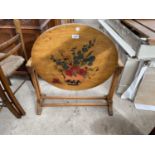 AN OAK FRAMED CIRCULAR FOLDING TABLE, THE TOP PAINTED WITH STILL LIFE FLOWERS