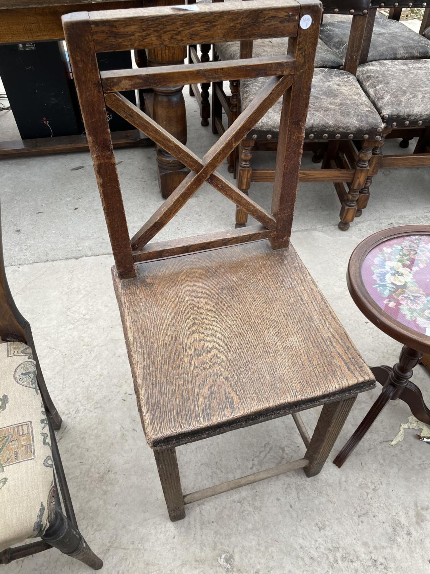 A VICTORIAN OAK KITCHEN CHAIR WITH SOLID SEAT AND X FRAME BACK