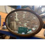 A MAHOGANY OVAL FRAMED BEVEL EDGE WALL MIRROR