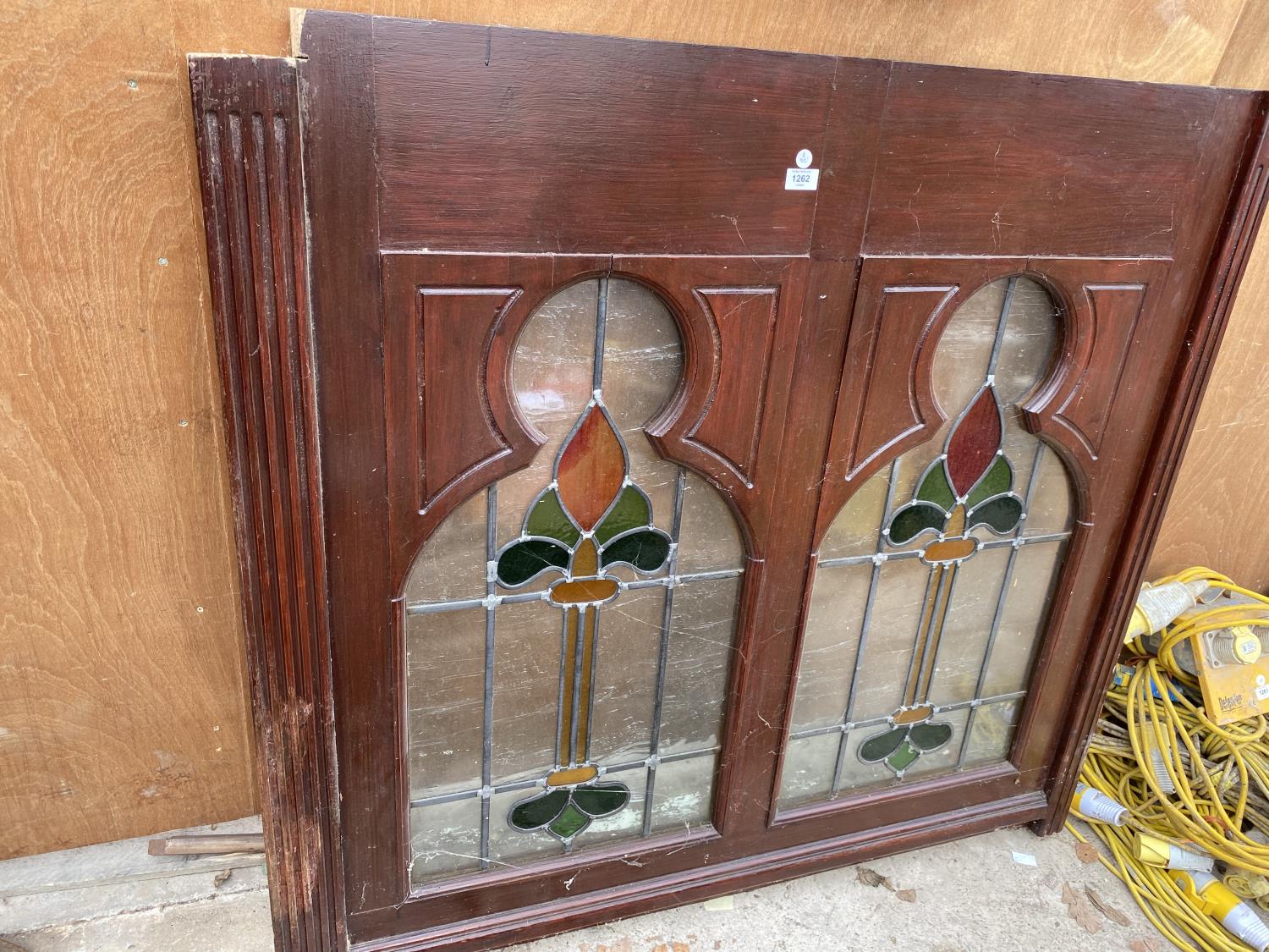 A WOODEN FRAMED WINDOW WITH STAINED GLASS