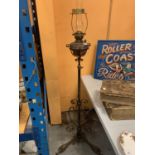 A VINTAGE OIL LAMP ON AN ADJUSTABLE METAL STAND