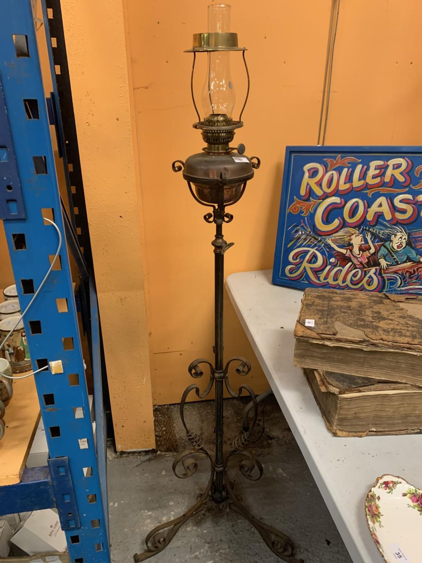 A VINTAGE OIL LAMP ON AN ADJUSTABLE METAL STAND