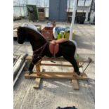 A VINTAGE ROCKING HORSE ON WOODEN BASE