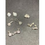 FIVE PAIRS OF SILVER EARRINGS TO INCLUDE FLOWER, STAR, TWIST AND DROP ETC WITH CLEAR STONES