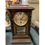 A WOODEN MANTEL CLOCK WITH PENDULUM AND KEY