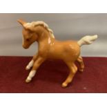 A BESWICK PALAMINO FOAL WITH RAISED TAIL