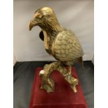 A LARGE BRASS SCULPTURE OF A BIRD OF PREY - 39CM HIGH