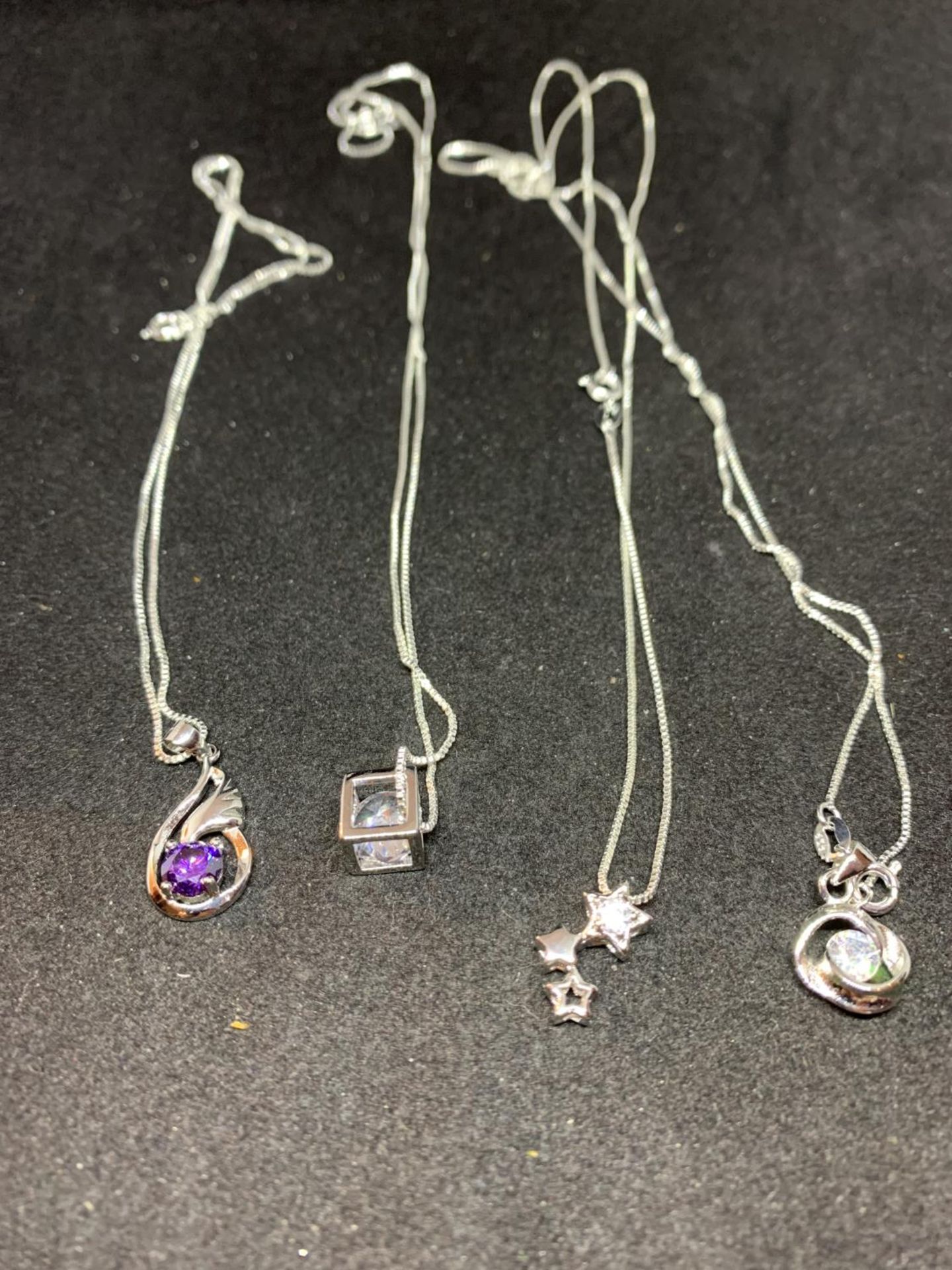 FOUR SILVER NECKLACES WITH CLEAR STONE PENDANTS TO INCLUDE A CUBE, STARS ETC - Image 2 of 6