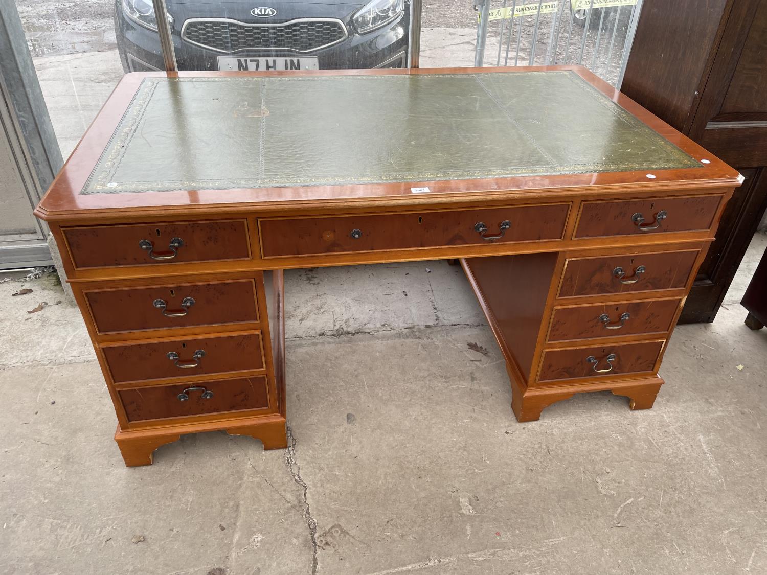 A REPRODUCTION YEW WOOD TWIN PEDESTAL DESK ENCLOSING NINE DRAWERS WITH INSET LEATHER TOP 60" X 36"