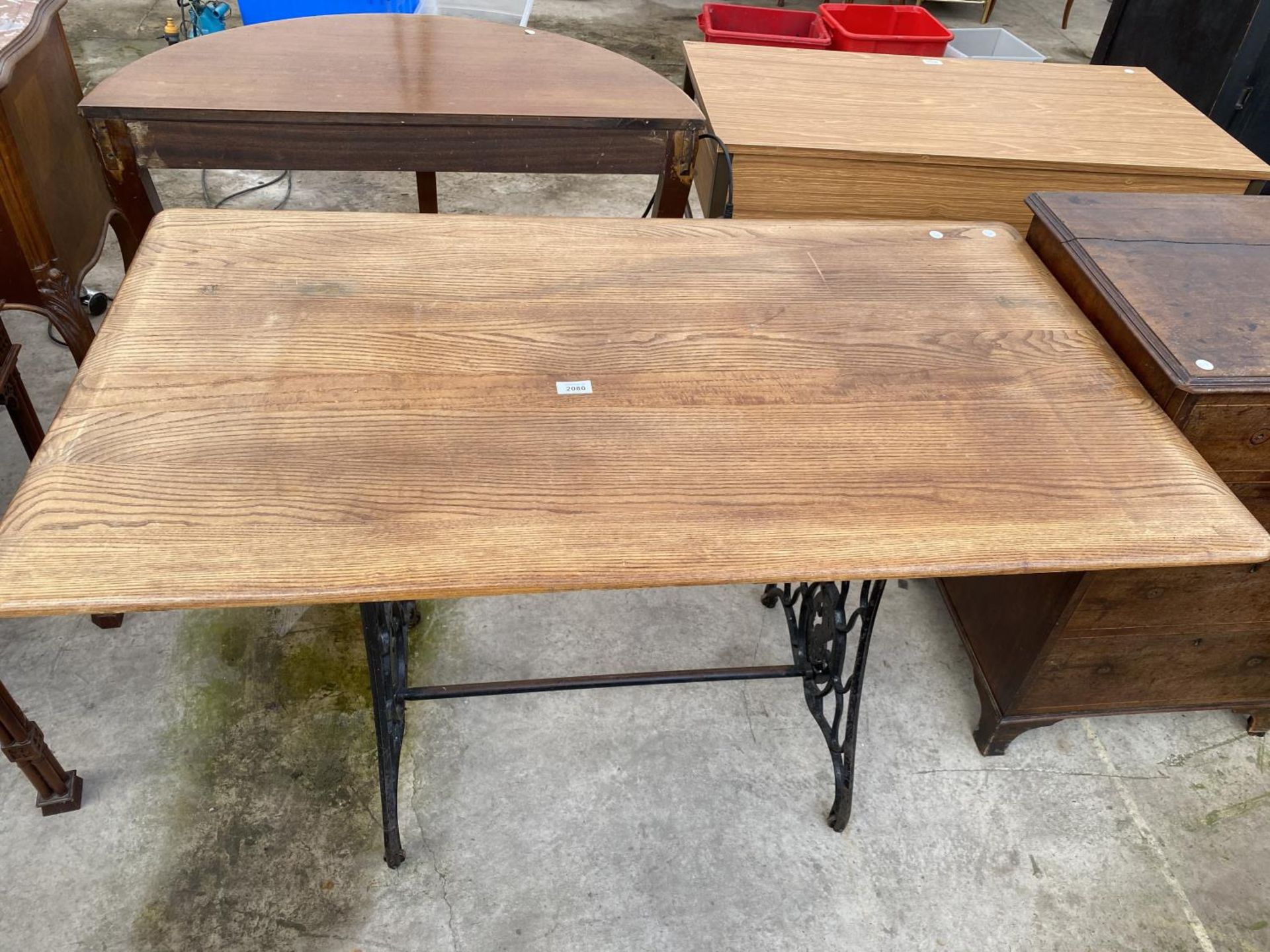 AN ELM TOP DINING TABLE ON CAST IRON SEWING MACHINE SUPPORTS (SINGER)