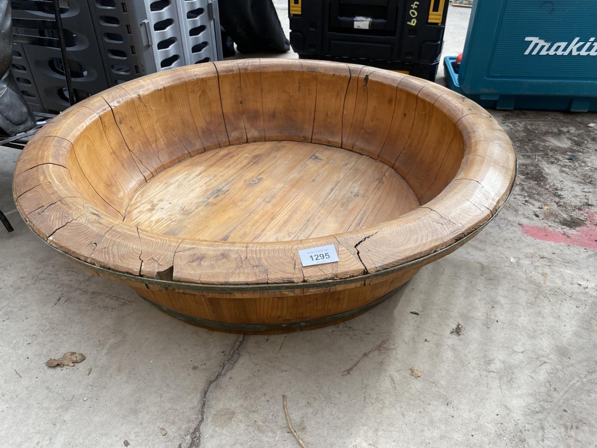 A LARGE WOODEN BOWL WITH METAL BANDING