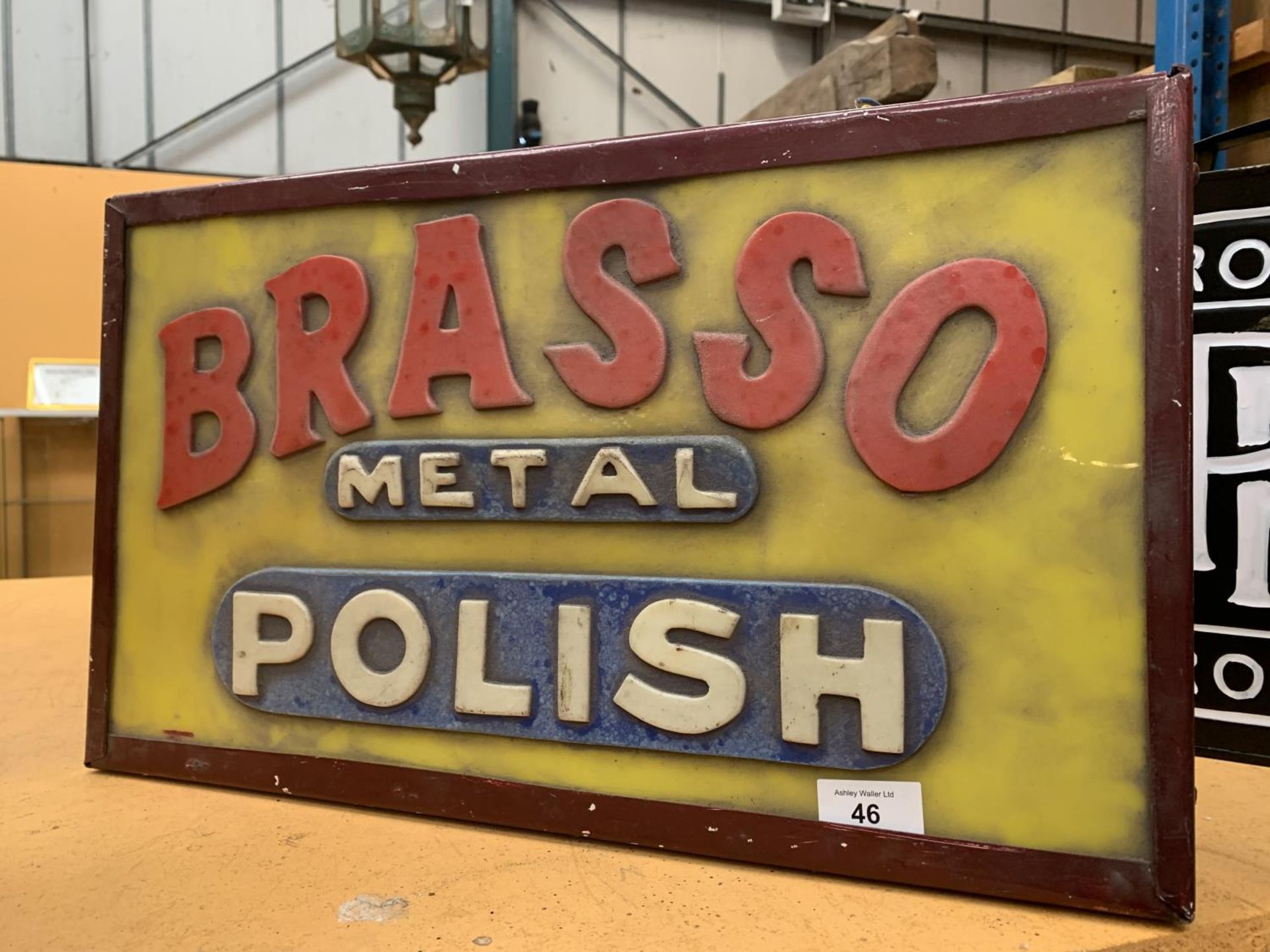 AN ILLUMINATED 'BRASSO' SIGN