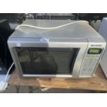 A SILVER SHARP MICROWAVE OVEN BELIEVED IN WORKING ORDER BUT NO WARRANTY