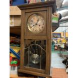 A VINTAGE WOODEN WALL CLOCK WITH BRASS AND GLASS DETAIL IN THE DOOR H:61CM