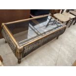 A WICKER FRAMED COFFEE TABLE WITH GLASS TOP 45" X 23"