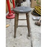 A VINTAGE WOODEN FOUR LEGGED STOOL